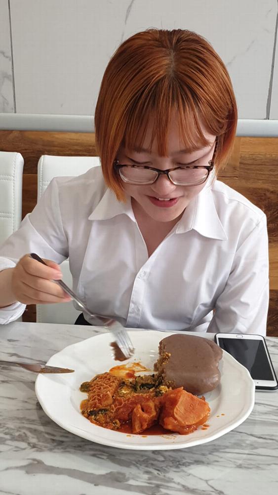 Woman eating an african dish in dokis restaurant